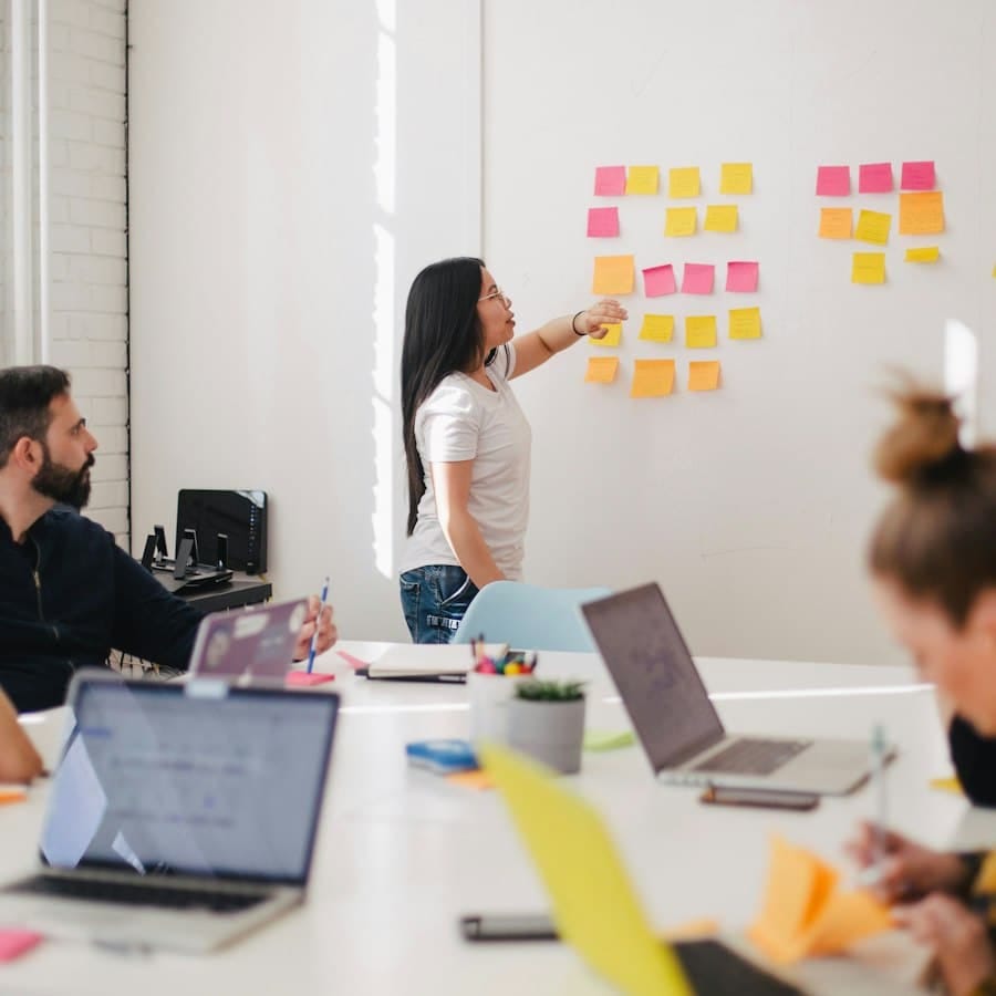 A team working through a wall of sticky notes in a meeting room.